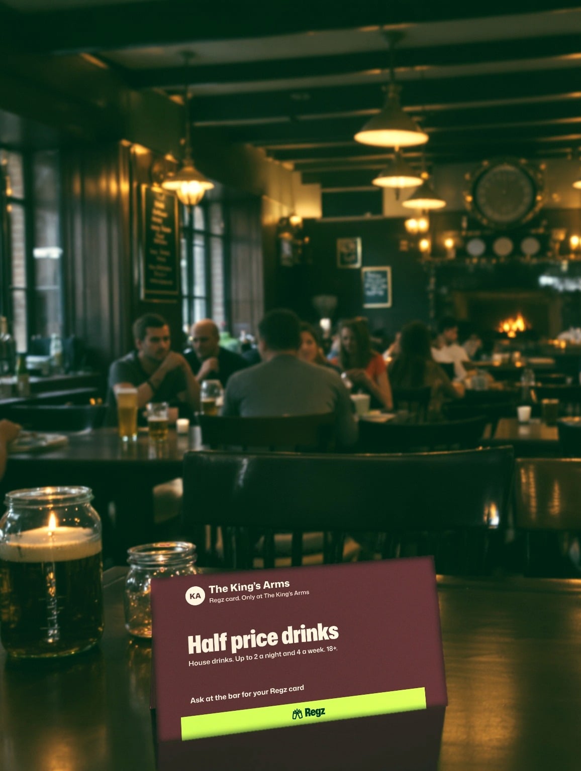 A table card for The King's Arms Regz card saying half price drinks, with the limits underneath, in a relaxed pub